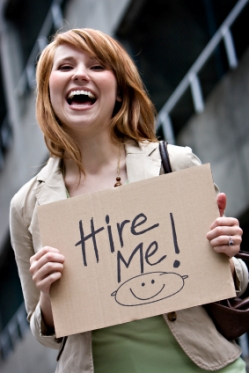 Young Woman with "Hire Me" Sign