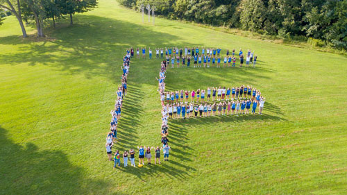 members of the Class of 2024 gather in the shape of an F
