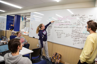students work at the whiteboard in the Mathematical Sciences department
