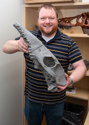 Dr. Thomas Hegna displays the 3 D printed skull of a Macrauchenia, an extinct hooved animal that lived in South America some 10,000 years ago, that students have created. Its four parts were printed separately and will be joined together in the final development stage.