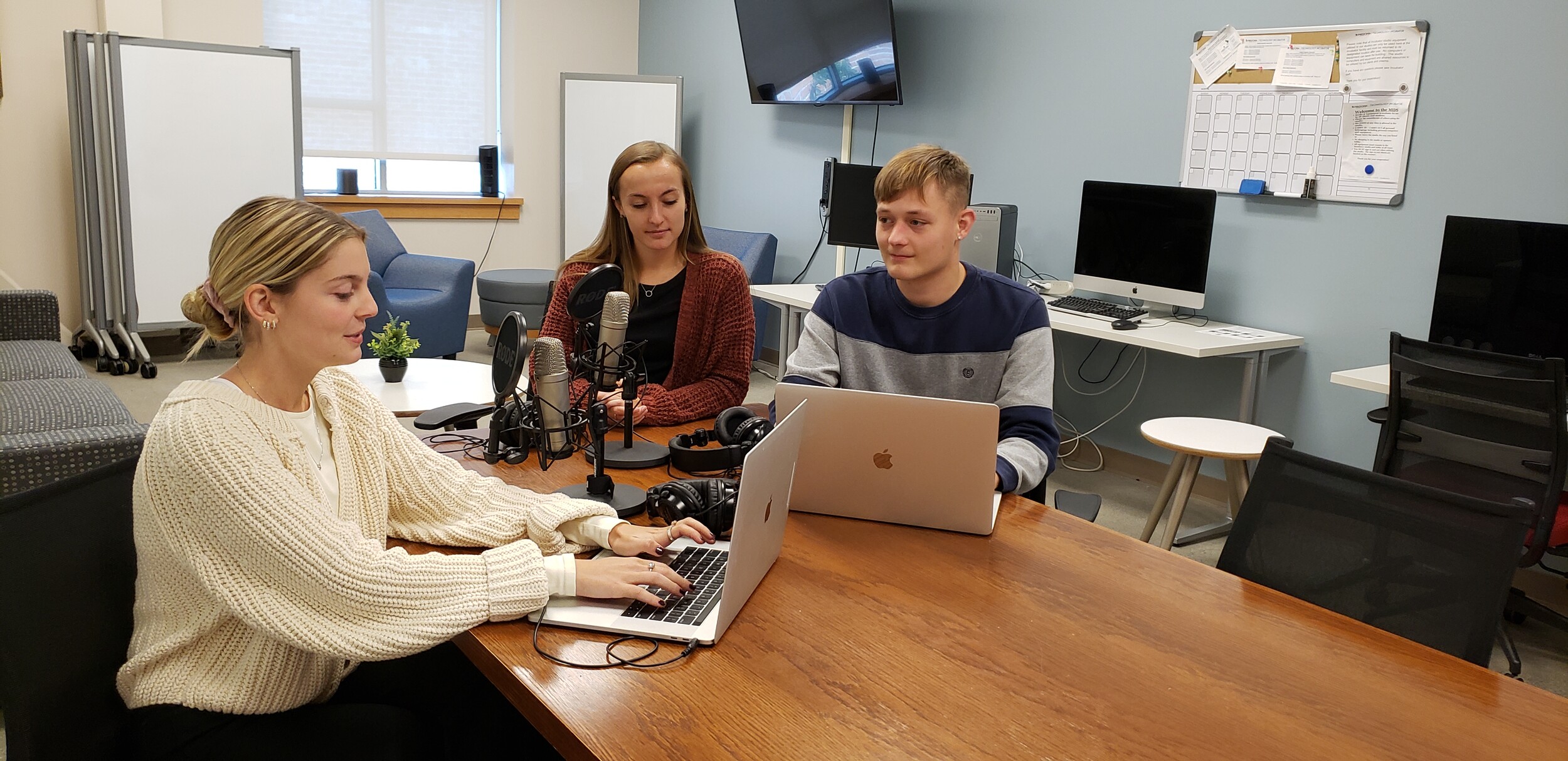 Megan Jobson, Jenna Hadley and Caleb Crampton working at a conference table in the Innovation Design Studio