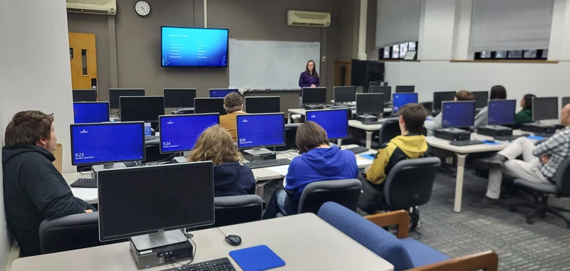 Lecturer Denise Joy in computer lab with students, Computer Science major