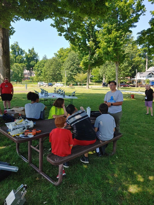 student researcher working with young students outside