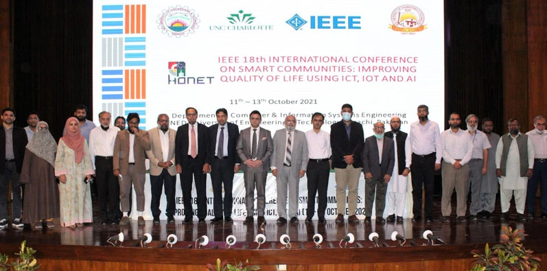 group of computer scientists in front of conference banner