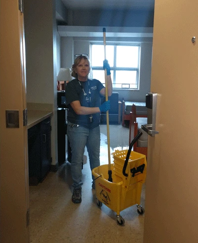 staff member cleans a room in residence hall