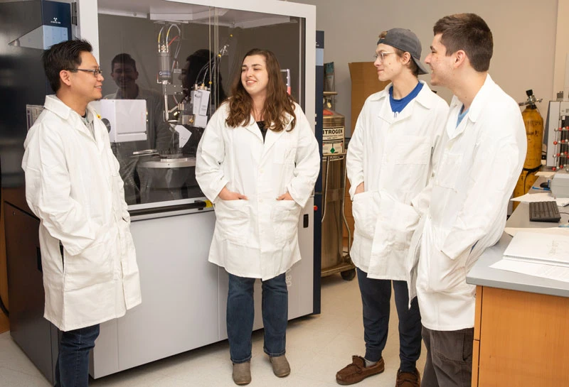 students with faculty member in lab