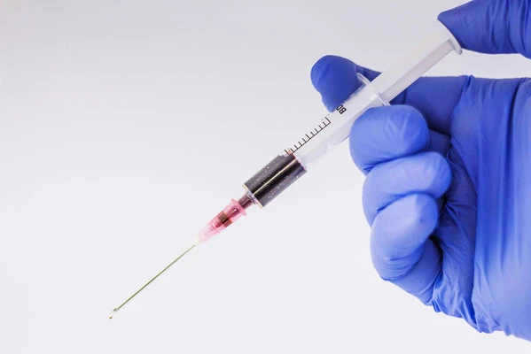 photo of a health worker holding a syringe