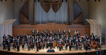 members of the College Symphony standing on the King Concert Hall stage.