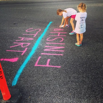 chalk drawing of a start and finish line with children