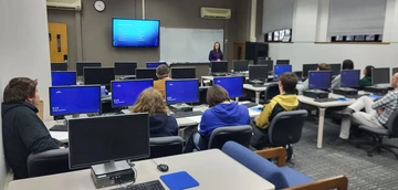 Lecturer Denise Joy in computer lab with students, Computer Science major