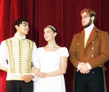 three cast members in costume standing