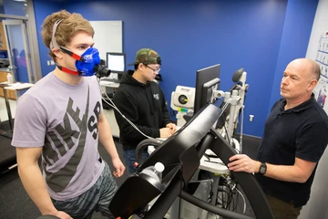 faculty member works with students on treadmill