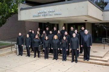 members of the choir standing outside of Mason Hall