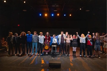 singers lined up on stage for an ovation