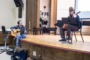 Dr. Nathan Huvard studies the fingering position of Justin Swan, a junior Sound Recording Technology major from Falconer, NY, as he plays a selection in Diers Recital Hall.