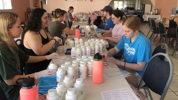 Students prepare pill bottles for distribution at the medical brigade pharmacy.