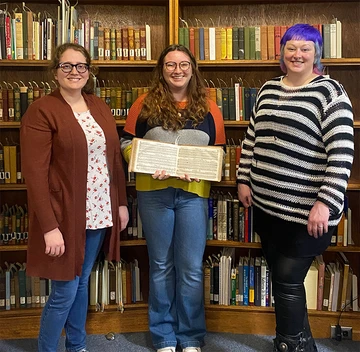 Angelina “Angie” Seamster, displaying a book of sheet music, is joined by Katelynn Telford (left), music and arts librarian, and Amanda “Mandi” Shepp, coordinator of Special Collections & Archives. 