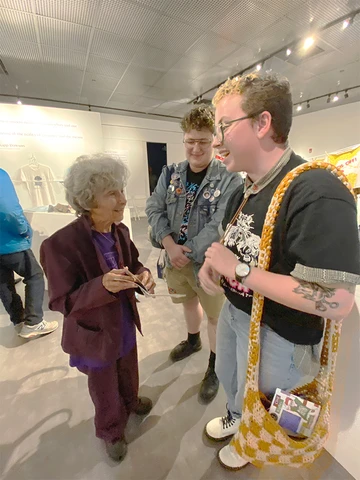 Jonah Grace (center) and Landon Lyons discuss the exhibition guide they created for the exhibition “Wearing the Movement” with Kipp Dawson, whose collection of t-shirts devoted to social justice movement is featured.