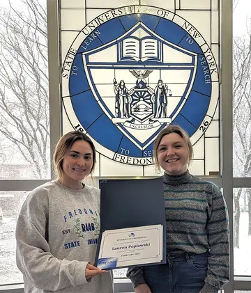 Lauren Poplawski (left) displays the certificate she received from Chautauqua Hall Residence Director Donna “DG” Good.