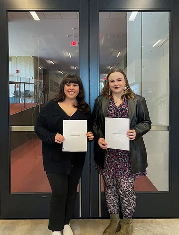 author and director standing in doorway holding scripts