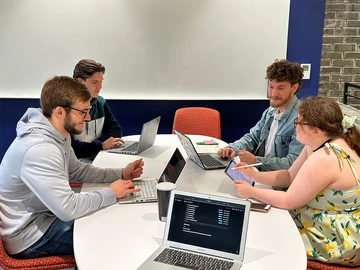 presentation computer is Computer Science students (from left) Ryan Plumer, Camron Walsh, Jared Russell and Anne Smith finalize the deliverables for the user and schema matching project.