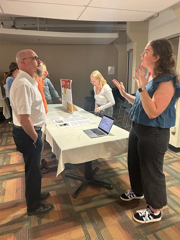 Social Work student describes her project to Dean Andy Karafa