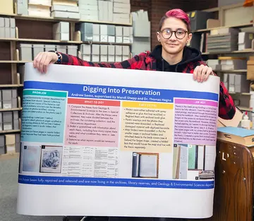 Andrew Semo, with his poster presentation, in Special Collections and  Archives in Reed Library.