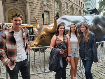 students on Wall Street in front of the iconic bull statue