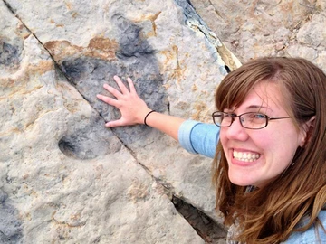 Dr. Sarah Sheffield, next to a Cretaceous dinosaur footprint.