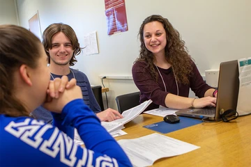 students meeting at a table with laptop on table