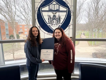Sydney Hawkins holding certificate and Kasling Hall Director Sabrina Sosa.