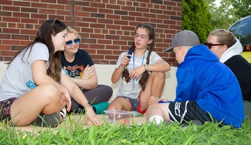 Graduate student Alexis Schuman (second from left) listens to one of her students as she outlines how to tackle their team’s assignment.