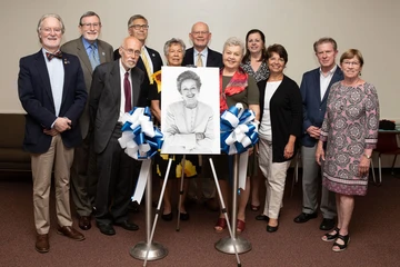 Gathering around a portrait of Kay Hardesty Logan, a philanthropist, musician and arts patron, at the dedication of the Logan Green Room at Rockefeller Arts Center.
