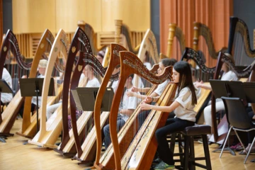 Students at a harp ensemble rehearsal.