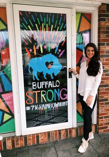 student in front of decorated door