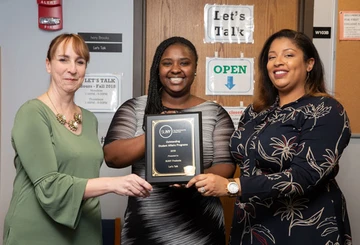 Proudly displaying Fredonia’s SUNY Outstanding Student Affairs Award plaque are (from left): Director Tracy Stenger and Ivory Br