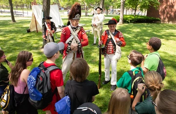 Students gather around a British encampment from the American Revolutionary War at last year’s Living History Day at Fredonia.