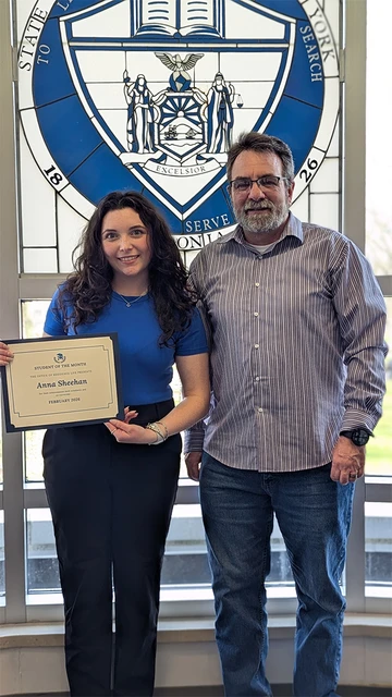 Anna Sheehan holding certificate standing with staff member who nominated her for the award