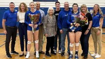 senior volleyball players with coaches and family in Dods Hall gymnasium