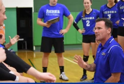 women's volleyball coach Geoff Braun instructs his players during a match