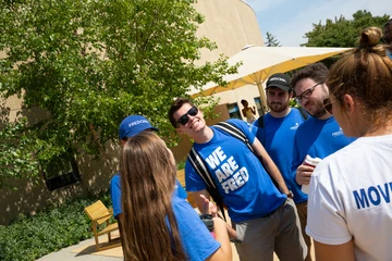 A group of students converse outside Williams Center