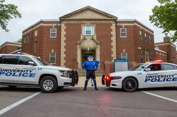 Freddy with University Police vehicles in front of Gregory Hall