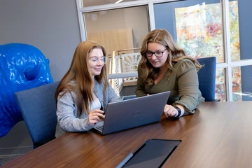 Fredonia students working together at a laptop