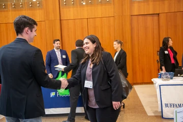 Young woman meeting business professionals at an event on campus while studying for a degree in accounting. Earn your bachelor's in Accounting  at SUNY Fredonia.