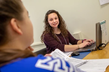 Student helping someone prepare their taxes