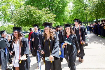 Fredonia students walking at graduation. Students who earn a degree in psychology go  