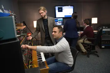 Student working with professor on music composition process with an organ