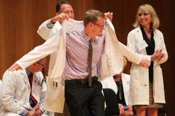 student receiving medical jacket