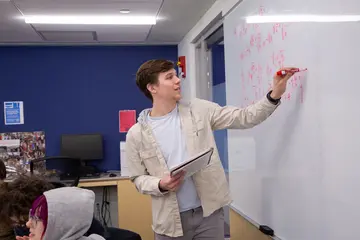 Fredonia math student showing work at the board. Fredonia students work collaboratively while earning a degree in math. 