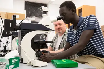 a biology student engages in research in a science center lab